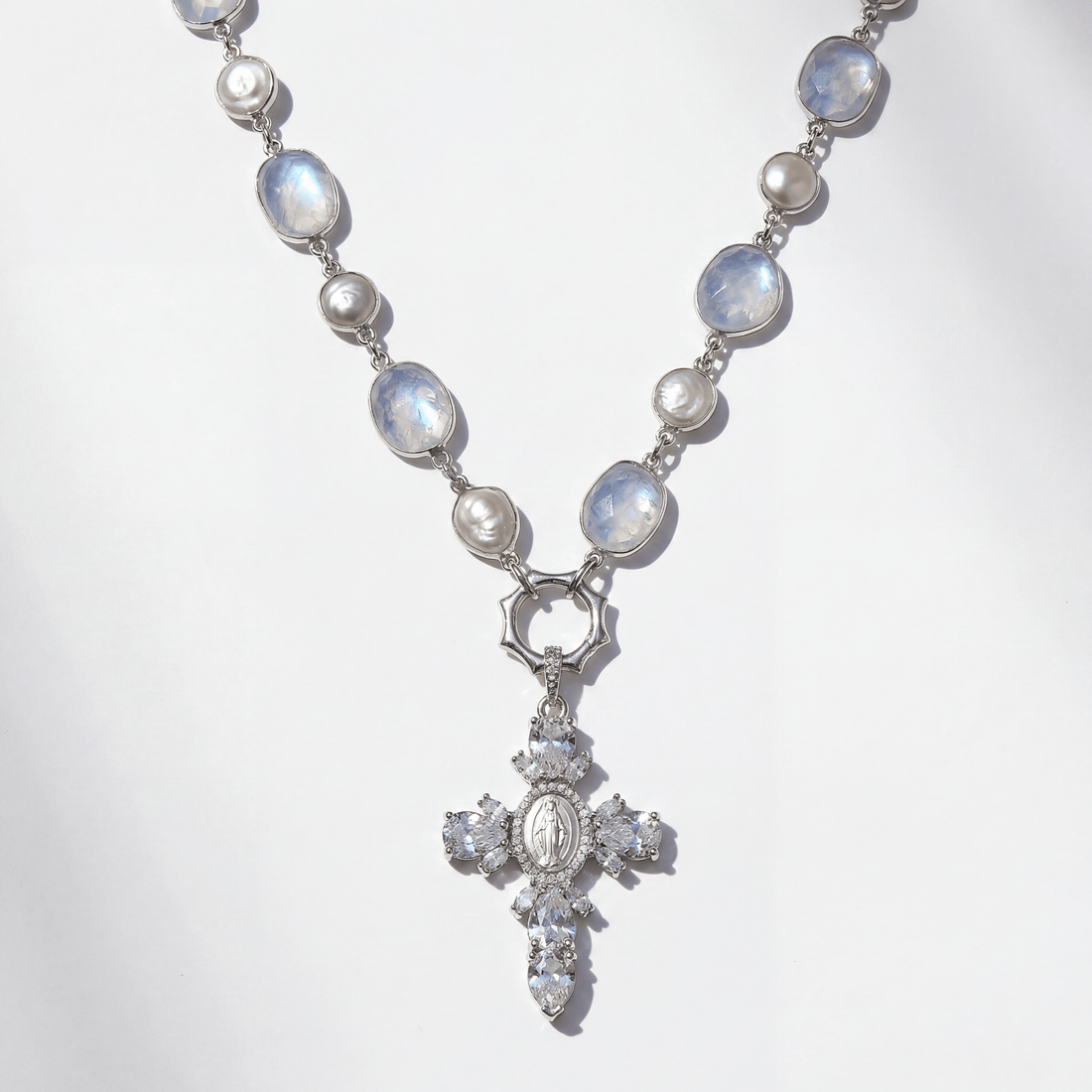 Necklace with moonstone and pearl beads and a cross pendant on a white background