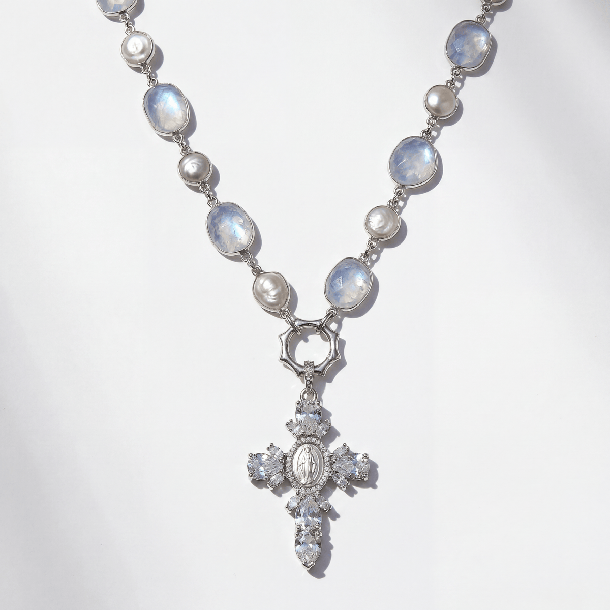 Necklace with moonstone and pearl beads and a cross pendant on a white background