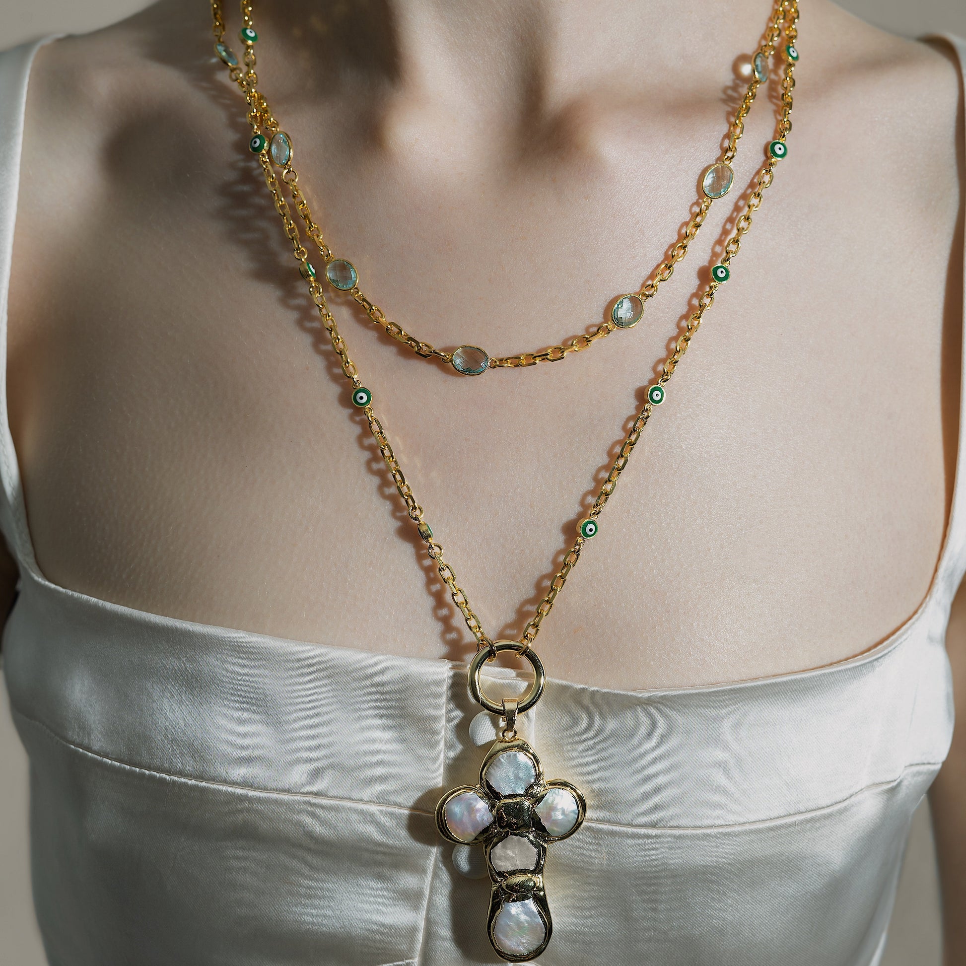 Necklace with a pendant on a person wearing a white top.
