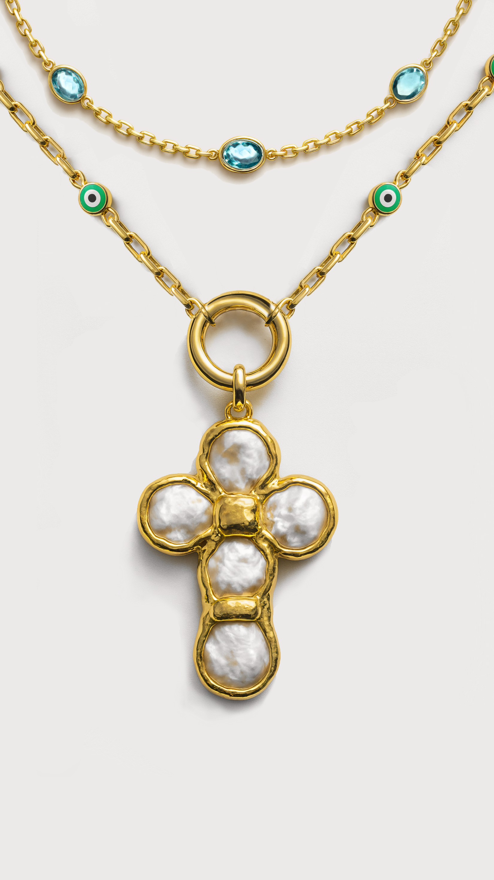 Gold necklace with a cross pendant on a light gray background