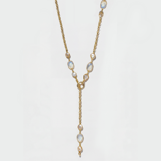 A gold Y-shaped lariat necklace featuring irregular white opal-like gemstones, displayed against a clean white background.