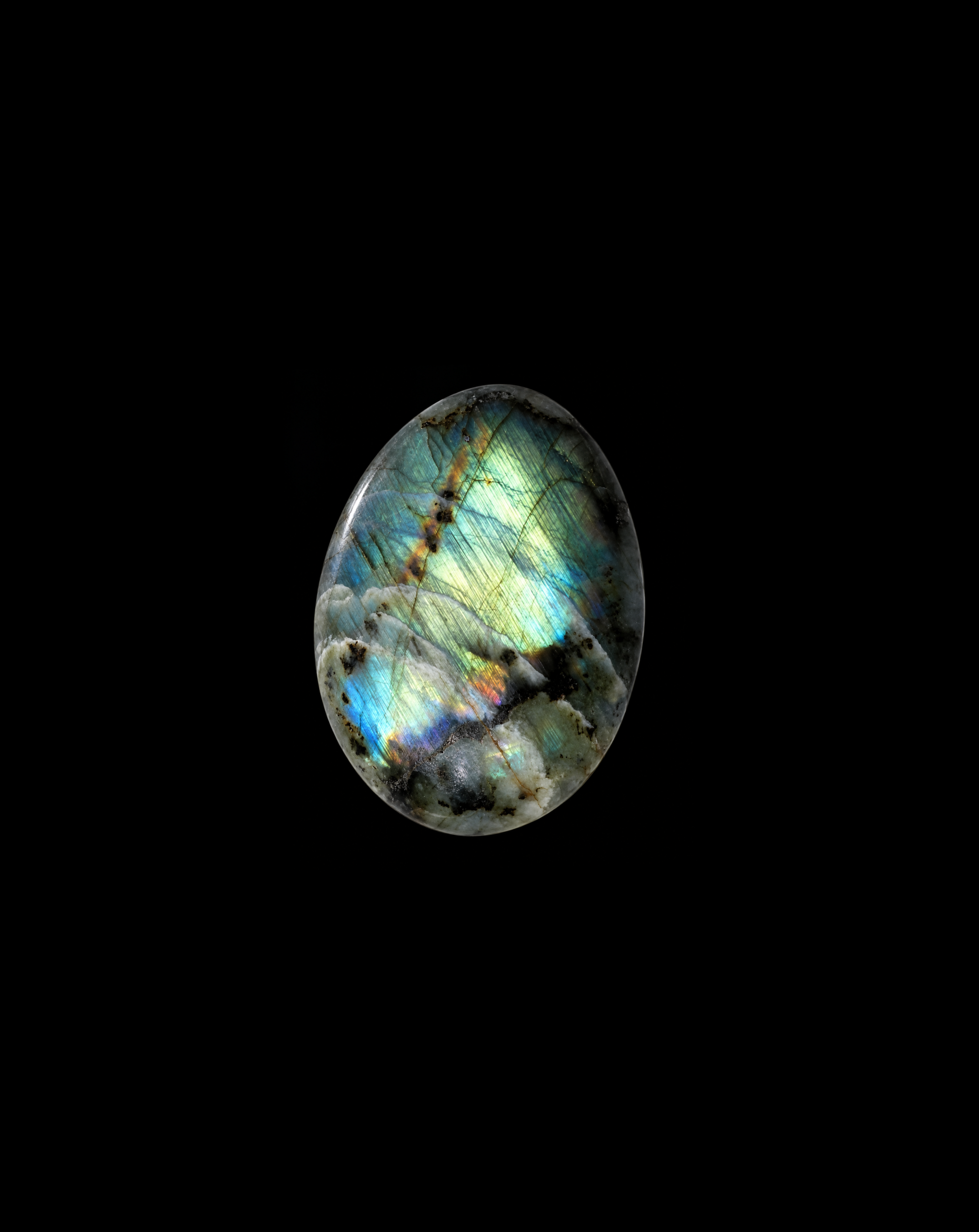 Iridescent labradorite cabochon against black