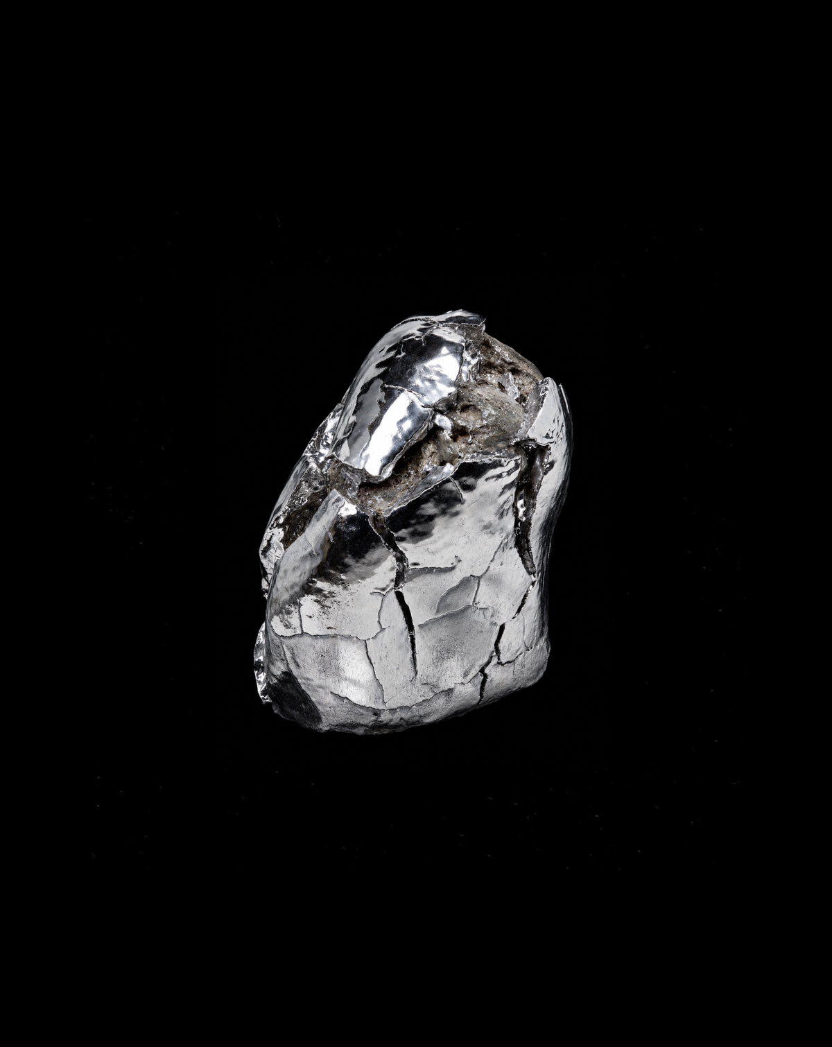 Abstract polished silver metal sculpture against black